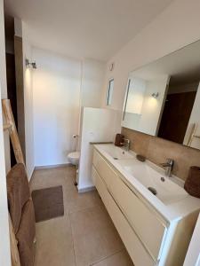 a bathroom with a sink and a mirror and a toilet at GypSea in Anse Marcel  +12 photos