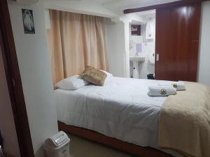 a bedroom with a bed with towels on it at HOTEL EL SOL dEL GALERAS in Pasto