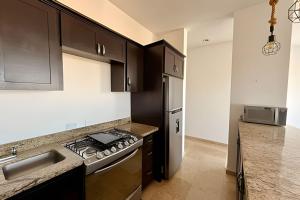 a kitchen with black cabinets and a stove top oven at Vista Colorada in El Bedito