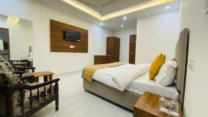 a bedroom with a bed and a tv on the wall at Hotel Ratti Inn in Mohali