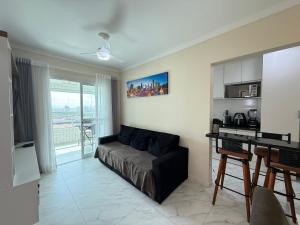 - un salon avec un canapé et un bureau dans l'établissement Apartamento Vista Mar Mirim 2 Dormitorios suite com Wifi para até 8 pessoas 1 vaga de estacionamento, à Praia Grande