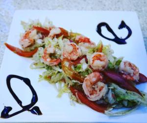a plate of food with shrimp on a salad at Zanzibar House Boutique Hotel in Matemwe