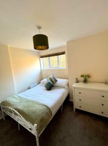 a small bedroom with a bed and a dresser at Cute Cornish Cottage in Saint Germans