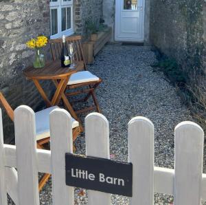 a white fence with a little barn sign on it at Cute Cornish Cottage in Saint Germans +13 photos