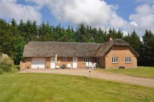 a large brick barn with white doors and a grass field at 10825-Ulfborg-Vester-Mosevej-35 in Øby
