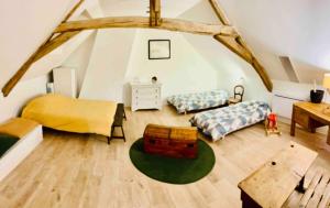a attic room with two beds and a table at Appartement dans maison avec jardin privatif 