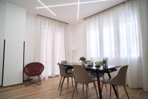 a dining room with a black table and chairs at Eschilo - Cairoli Apartments in Gela