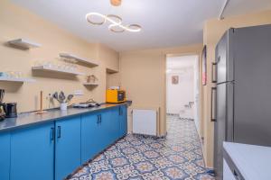 a kitchen with blue cabinets and a tile floor at Cozy Private House in Kadikoy in Istanbul