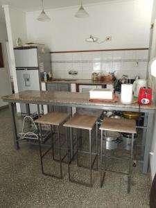 una cucina con bancone e sgabelli di Casa en Tandil a Tandil