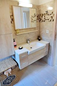 een badkamer met een witte wastafel en een spiegel bij Voula's Traditional House in Meyisti