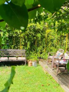 La Celle-sous-GouzonにあるLe Voyage - Séjour atypique proche de Colmarの木の庭園に座る木製のベンチ2つ