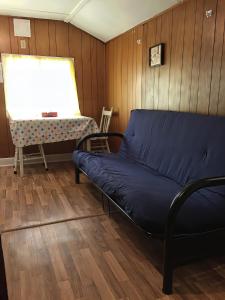 Sofá azul en una habitación con mesa en 1-Bedroom Cottage #2 - Ambleside, en Kawartha Lakes