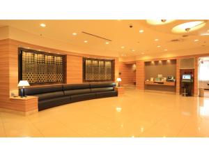 a lobby with a black couch in a building at Smile Hotel Tokushima - Vacation STAY 10502v in Tokushima