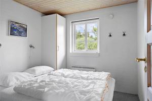 una camera da letto bianca con un letto e una finestra di 60857-Ulfborg-Illeborgvej-38 a Fjand Gårde