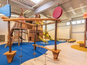 een kinderspeelplaats met schommels en een glijbaan bij 6 Personen Ferienhaus in Wendtorf in Wendtorf