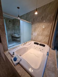 a large white tub in a bathroom with a sink at Pousada Kaetê in Paraty +40 photos