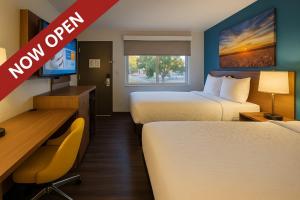 ロックスプリングスにあるDays Inn by Wyndham Rock Springsのベッド2台、机、テレビが備わったホテルの部屋