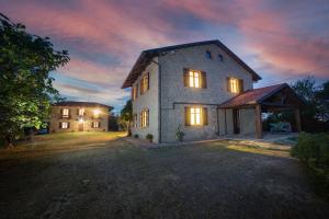 a large stone house with lights on in a yard at LA CASA DI TALIN - Camere e appartamenti - Accoglienza adults only in Serravalle delle Langhe