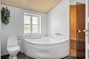 a white bathroom with a tub and a toilet at 10704-Ulfborg-Gaffelbjergvej-49 in Øhuse +19 photos
