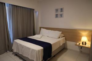 a hotel room with a bed and a window at Makia Beach muro alto in Ipojuca