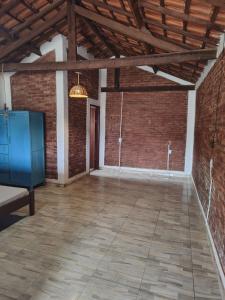 an empty room with a brick wall and a wooden ceiling at Chale das estrelas in São Thomé das Letras