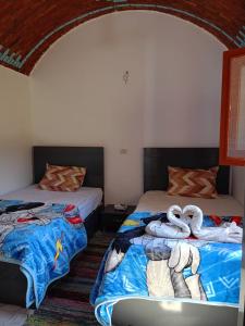 two swans laying on beds in a room at Reagan House in Aswan +35 photos