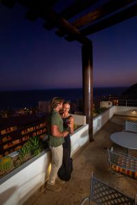 Ein Mann und eine Frau stehen auf einem Gebäude in der Unterkunft Sandos Finisterra All Inclusive in Cabo San Lucas