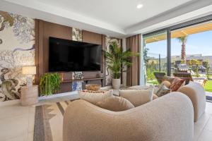 a living room with two chairs and a flat screen tv at Evergreen Exclusive in Mijas Costa