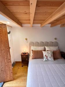 une chambre avec un grand lit et un plafond en bois dans l'établissement Ferreiro do Cabeço House, à Bandeiras