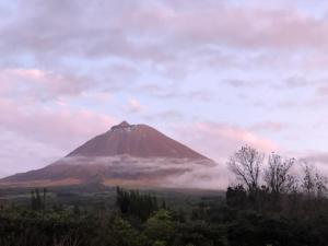 a mountain in the distance with a cloudy sky at Ferreiro do Cabeço House in Bandeiras