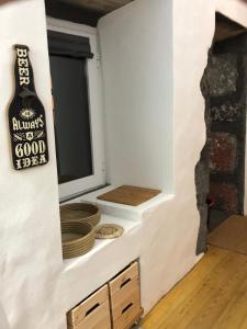 une pièce avec une bouteille de bière sur un mur dans l'établissement Ferreiro do Cabeço House, à Bandeiras