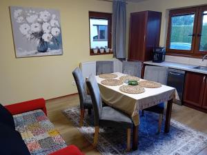a dining room with a table and chairs and a kitchen at Útulný Domček Privat Bedrich in Poprad