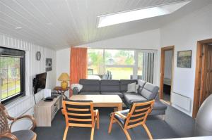 een woonkamer met een bank, een tafel en stoelen bij 30370-Ulfborg-Lathyrusvej-314 in Vang +16 foto's