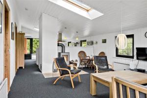 een woonkamer met een tafel en stoelen bij 30370-Ulfborg-Lathyrusvej-314 in Vang