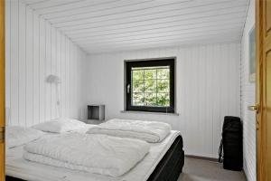 een witte kamer met een groot bed en een raam bij 30370-Ulfborg-Lathyrusvej-314 in Vang