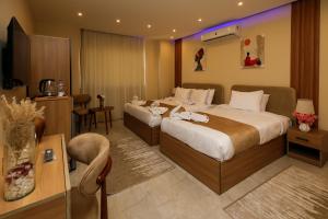 ein Hotelzimmer mit zwei Betten und einem Fernseher in der Unterkunft pyramids palace view iNN in Kairo