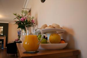 a bowl of fruit and a glass of orange juice at Ashberry Guest House in Penrith