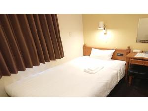 a hotel room with a bed and a desk with a telephone at Smile Hotel Kobe Motomachi - Vacation STAY 05016v in Kobe