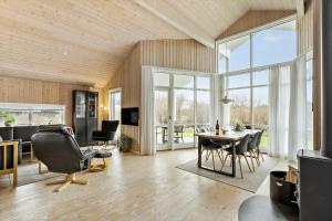 een grote woonkamer met een tafel en stoelen bij 60836-Ulfborg-Fjand-Strand-29 in Fjand Gårde