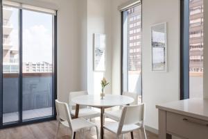 a dining room with a table and chairs and windows at Kasa at The Waller Austin in Austin +25 photos