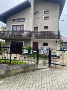 a house with a fence in front of it at Pokoje na wynajem "Pod Lasem" in Balice