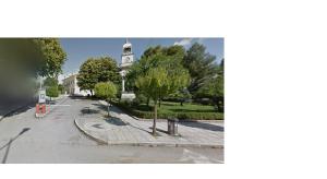 a street with a building with a clock tower at BlackGeorge Apartment in Ioannina