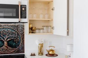 a kitchen with a microwave over a stove with a counter at Brass Apple Cottage in Campbell River +18 photos