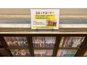 a shelf filled with dvds with a sign on it at Smile Hotel Utsunomiya Higashiguchi - Vacation STAY 12842v in Utsunomiya