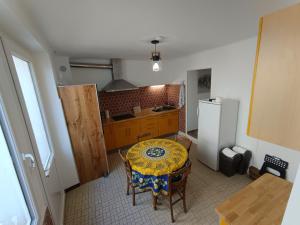 a small kitchen with a table and a refrigerator at Aux lits de la loire in Champtoceaux