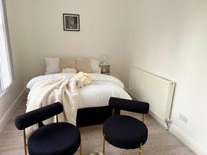 a bedroom with a bed with two stools in it at Edgbaston Retreat-Birmingham City Centre-Double Room in a shared two bedroom apartment in Birmingham