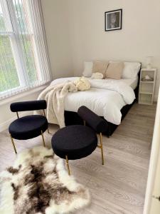 a bedroom with a bed with two chairs and a rug at Edgbaston Retreat-Birmingham City Centre-Double Room in a shared two bedroom apartment in Birmingham