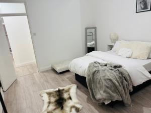 a bedroom with a bed with a blanket and a mirror at Edgbaston Retreat-Birmingham City Centre-Double Room in a shared two bedroom apartment in Birmingham +1 photo