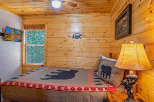 Un dormitorio con una cama en una cabaña de troncos en Paradise at the Smokies Cabin with HOT TUB!, en Sevierville