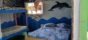 a bedroom with a bed and a mural of a dolphin at Hostal el peñón in Buenaventura +265 photos